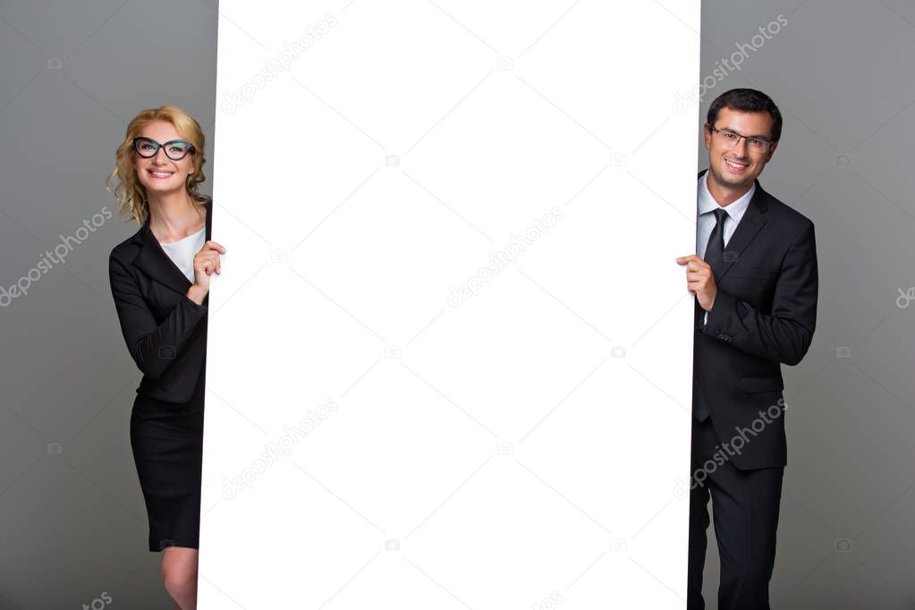Businessman and business woman with big empty poster