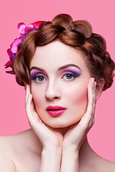 Vacker flicka med ljusa smink och rosa hatt — Stockfoto