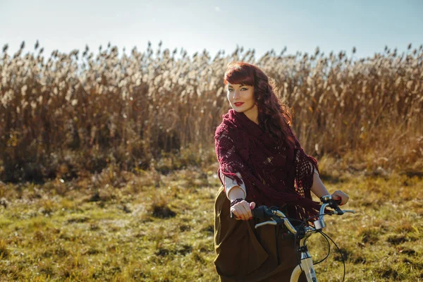 Красивая девушка катается на велосипеде в поле — стоковое фото