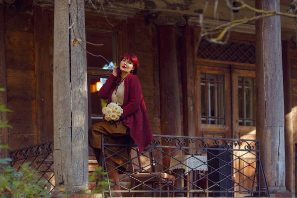 Девушка сидит на балконе старого дома — стоковое фото