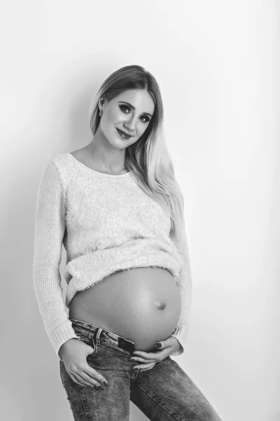 Красивая беременная женщина в джинсах — стоковое фото