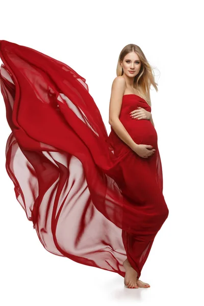 Беременная девушка в красном платье — стоковое фото