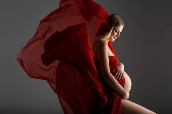Terhes nő piros ruhában — Stock Fotó