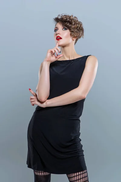 Nainen poseeraa pieni musta mekko — kuvapankkivalokuva