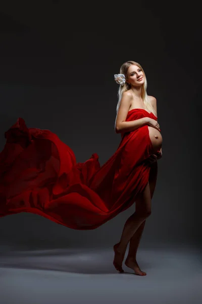 Kobieta w ciąży w czerwonej sukience — Zdjęcie stockowe