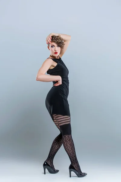 Flicka poserar i liten svart klänning — Stockfoto