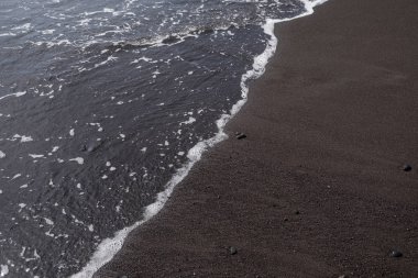 Üzerinde siyah kumlu plaj su