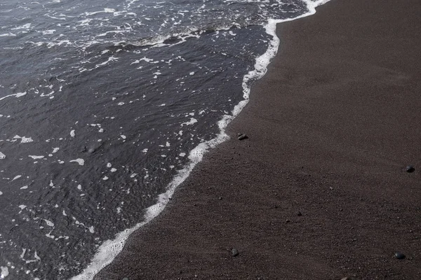 Eau sur la plage de sable noir — Photo