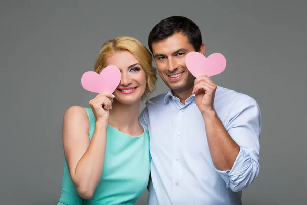 Pareja sonriente sosteniendo corazones —  Fotos de Stock