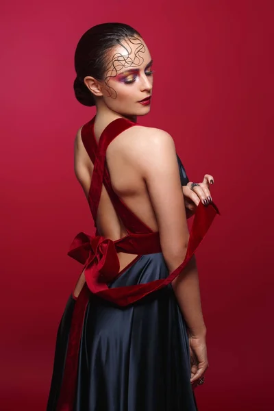 Hermosa mujer en vestido de seda con lazo rojo — Foto de Stock