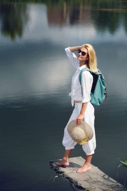 Göl kenarında oturan genç kadın