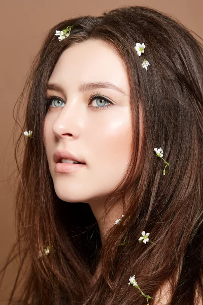 Menina com muitas flores pequenas no cabelo longo — Fotografia de Stock