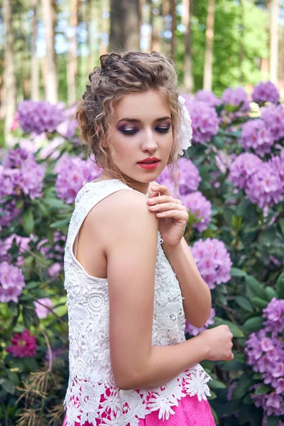 Flicka i klänning i rhododendron trädgård — Stockfoto