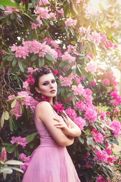 Дівчина в сукні в саду рододендрона — стокове фото