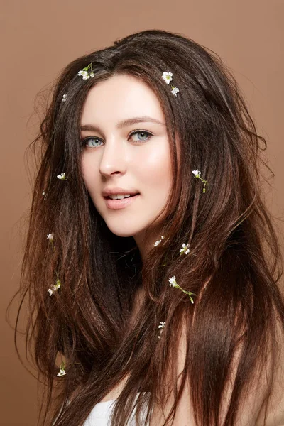 Девушка с большим количеством маленьких цветов в длинных волосах — стоковое фото