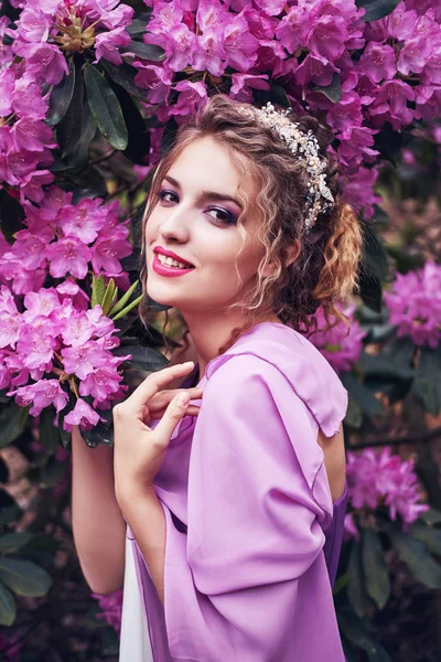 Flicka i klänning i rhododendron trädgård — Stockfoto
