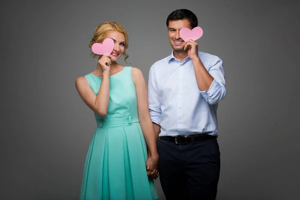 Belo casal segurando corações rosa — Fotografia de Stock