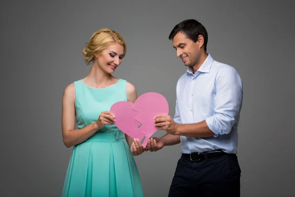 Beautiful couple holding pink broken heart — Stock Photo, Image