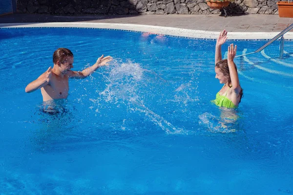 男孩和女孩在游泳池里玩得很开心 — 图库照片