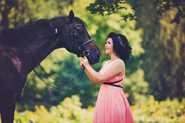 Belle fille en robe avec cheval — Photo