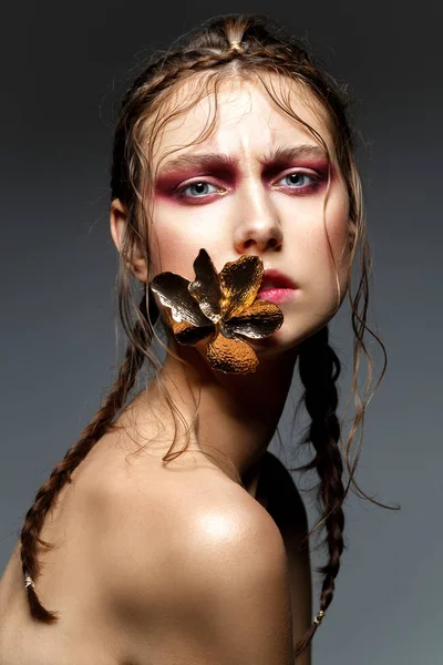 Menina bonita com tranças modernas e flor de metal na boca — Fotografia de Stock