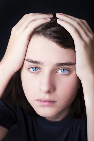 Een portret van een knappe blauwe ogen tiener op donkere achtergrond — Stockfoto