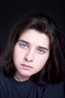 Koyu arka plan üzerinde bir yakışıklı mavi gözlü genç bir portresi