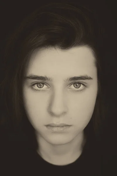 Un portrait d'un bel adolescent sur fond sombre.Style vintage — Photo