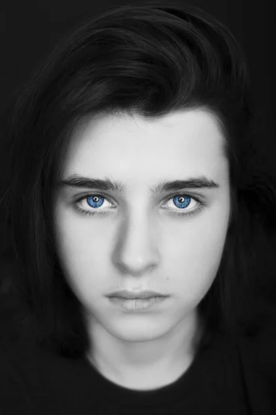 Porträt eines hübschen Teenagers mit blauen Augen auf dunklem Hintergrund. — Stockfoto