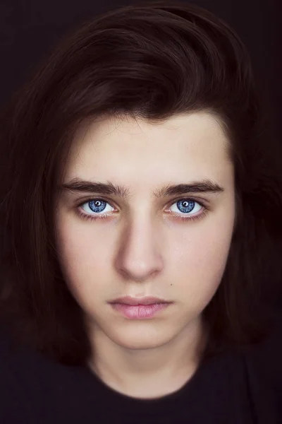 Um retrato de um belo adolescente no fundo escuro . — Fotografia de Stock