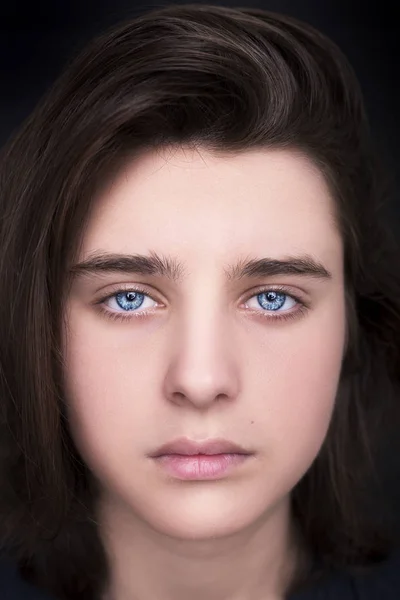 Portrait d'un bel adolescent aux yeux bleus sur fond sombre — Photo