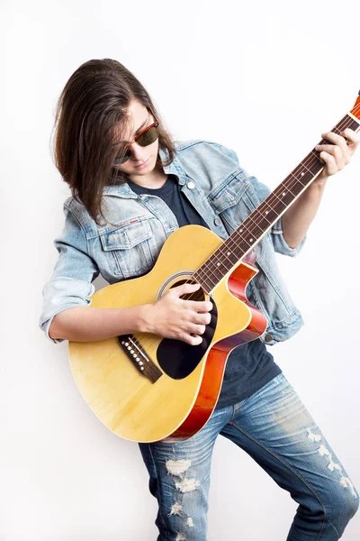 Модный портрет подростка, играющего на гитаре в студии — стоковое фото