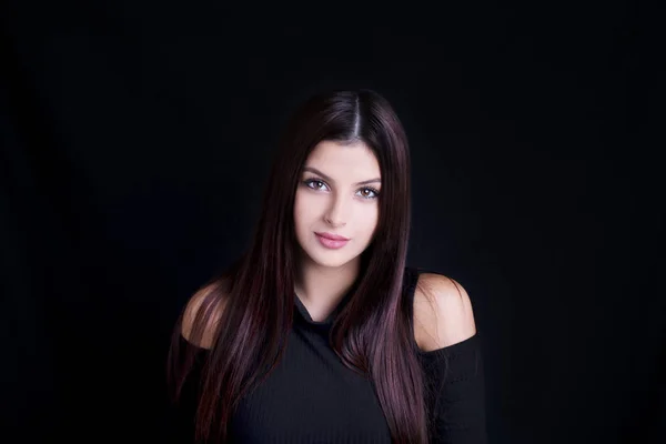 Young attractive woman with long black hair on black background. — Stock Photo, Image