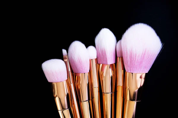 Professional makeup brushes collection on black background