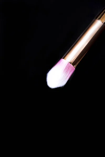 Fekete háttér fehér-pink smink brushe közelről. — Stock Fotó