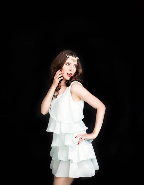 Young brunette lady in turquoise dress posing on black background