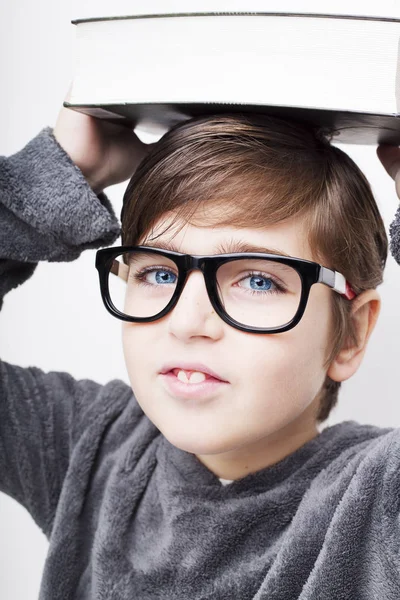 Porträt eines kleinen gutaussehenden Jungen mit Brille und Buch. i — Stockfoto