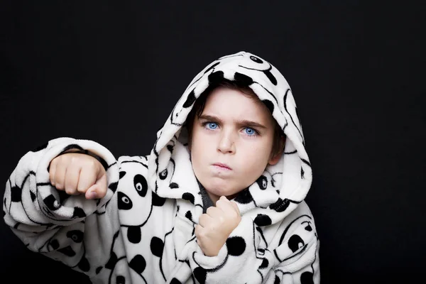 Retrato de um menino bonito em roupão de banho Panda em um backgroud preto — Fotografia de Stock