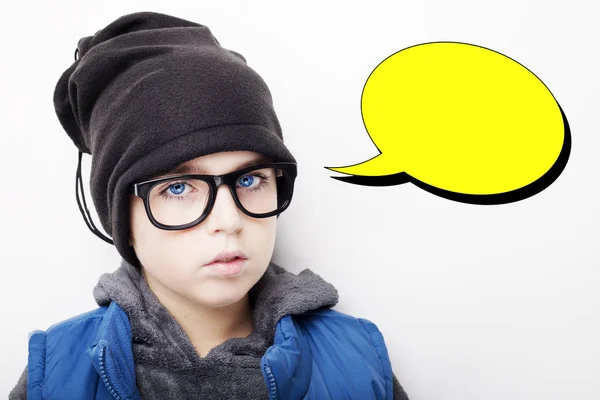 Knappe jongen draagt zwarte pet en bril met een lege gedachte zeepbel. Geïsoleerd op witte achtergrond — Stockfoto
