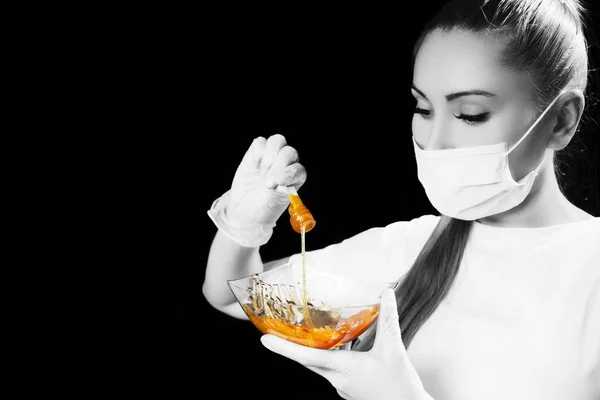 Woman with sugar hair removing paste on black background