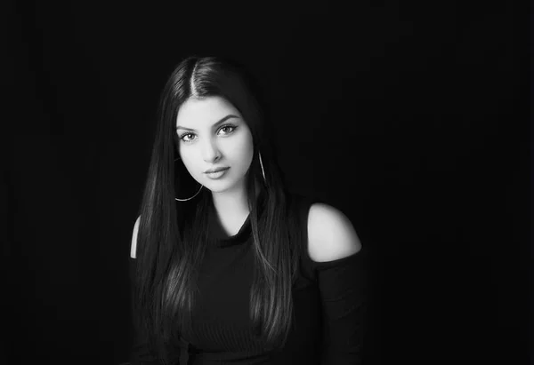 Jonge aantrekkelijke vrouw met lange zwarte haren op zwarte achtergrond. — Stockfoto