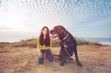 Küçük kız evde beslenen hayvan köpeğiyle oynuyor