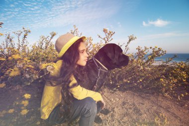 Küçük kız evde beslenen hayvan köpeğiyle oynuyor