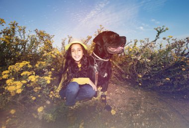 Küçük kız evde beslenen hayvan köpeğiyle oynuyor