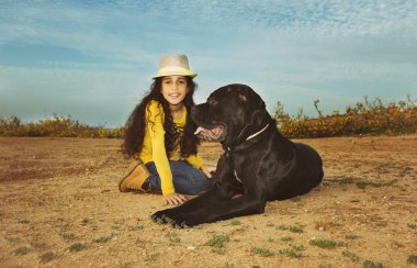 Küçük kız evde beslenen hayvan köpeğiyle oynuyor