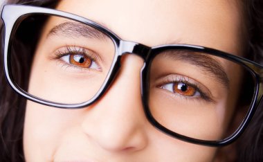 Gözlük takan güzel bir genç kızın görüntüsü. Yakın çekim.