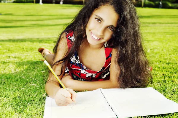 Güzel bir kız kalp parkta çizer.