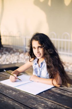 Güzel bir kız kalp parkta çizer.