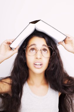 Sevimli kız gözlük ve kafasına kitap okuyor 