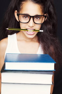 Gözlük ve kalem ile küçük kız kitapları tutar